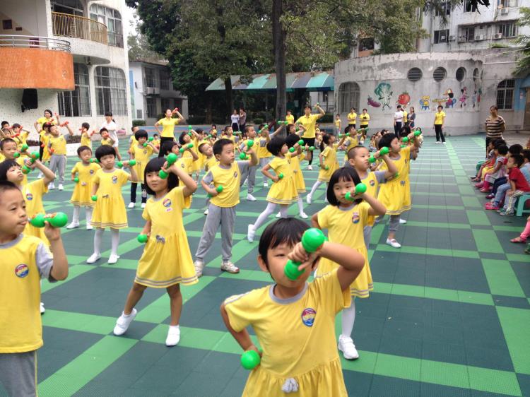 2014年10月30日上午,华南理工大学附属幼儿园中班、大班级小朋友迎来了这个学期的早操观摩活动。本学期我们本着让幼儿锻炼身体,快乐做操的理念,结合早操活动的规范性、科学性、趣味性,老师们精心挑选充满童趣的早操音乐和编排早操,大班级创编了哑铃操、中班级创编了红旗操、小班级创编了动物模仿操,操节后再加上活泼有趣的双人舞,使整个早操活动变得欢快且温馨,许多孩子都带着微笑做早操,积极性大大提高了。瞧,孩子们做得多投入啊!